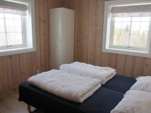 two beds in a room with two windows at Skåbu Hytter og Camping in Skåbu