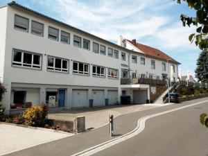 ein weißes Gebäude an der Straßenseite in der Unterkunft BodenSEE Gästehaus Tettnang ALBERGO in Tettnang