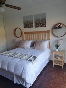 a large bed in a bedroom with two mirrors on the wall at Alu Guesthouse in Roodepoort