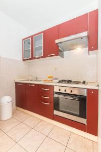 a kitchen with red cabinets and a stove at Apartment Luka in Ivan Dolac