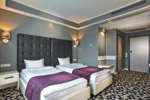 a bedroom with two beds and a large headboard at Manufactura Design-Hotel in Khodosovka +36 photos