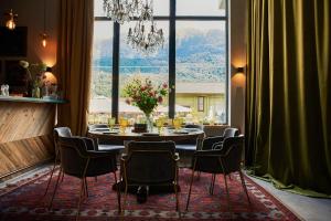 a dining room with a table and chairs and a large window at HILLS POLYANA Hotel & SPA I ОТЕЛЬ ХИЛЛС ПОЛЯНА in Krasnaya Polyana