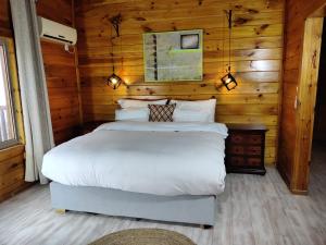 a bedroom with a bed in a log cabin at Vibe Naftali Estate in Ramot Naftali