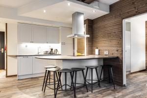 una cucina con mobili bianchi e sgabelli da bar di RukaValley Unique75 a Ruka