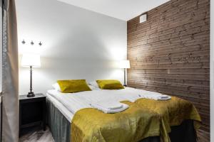 een slaapkamer met een bed en een bakstenen muur bij RukaValley Unique75 in Ruka