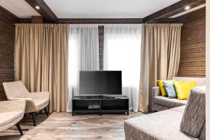 un soggiorno con TV a schermo piatto e divano di RukaValley Unique75 a Ruka