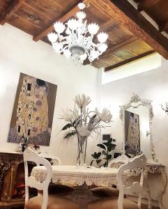 Habitación con mesa con sillas y lámpara de araña. en Stella del Mar S.Stefano, en Bolonia