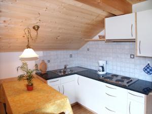 a kitchen with white cabinets and a sink at Apartments Feldsagerhof in Villabassa