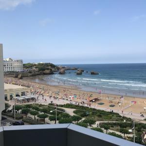 uma vista para uma praia com pessoas e para o oceano em BIARRITZ Victoria Surf em Biarritz