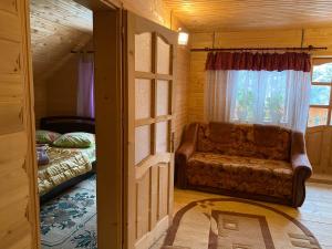 a living room with a couch and a window at Villa Maria in Yablunytsya