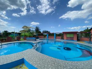 einen Pool in einem Resort mit blauem Himmel in der Unterkunft RedDoorz Plus @ Lhexlyn Resort San Narciso in San Narciso