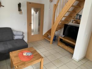 a living room with a couch a table and a tv at Ferienhaus Elida in Krummin