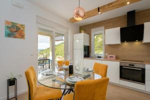 a kitchen and dining room with a glass table and chairs at VILA ROZA in Prožura