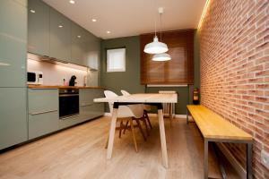 a kitchen with a table and a brick wall at La Casa de Mozo in Avila
