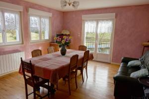 una sala da pranzo con tavolo e vaso di fiori di La Crova a Félines