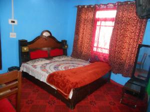 a bedroom with a bed with a red comforter and a window at Alamdar guest house in Srinagar
