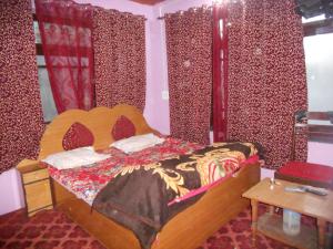 a bedroom with a wooden bed with red curtains at Alamdar guest house in Srinagar