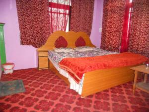 um quarto com uma cama com um edredão vermelho em Alamdar guest house em Srinagar