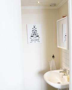 baño con lavabo y árbol de Navidad en la pared en Järjagården Hostel, en Storsele