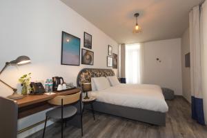 a hotel room with a bed and a desk with a desk at Lady Todd in Sliema
