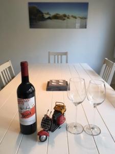 una botella de vino y dos copas de vino en una mesa en Royal III, en Knokke-Heist