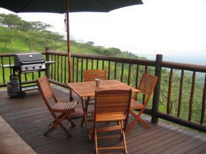a wooden table and chairs on a deck with a grill at Bonnie View Game Lodge in Hilton