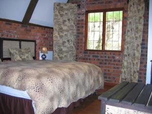 sypialnia z łóżkiem i ceglaną ścianą w obiekcie Bonnie View Game Lodge w mieście Hilton