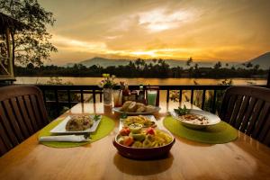 a table with food on it with a view of a lake at Green Mango Bungalows in Kampot