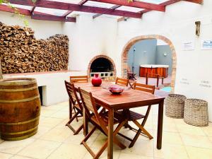 einen Holztisch und Stühle in einem Zimmer mit einem Fass in der Unterkunft Abington Manor Fish Hoek Guesthouse in Fish hoek