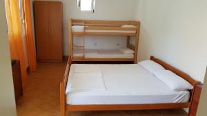 a bedroom with a bunk bed with white sheets at Studios Velika Plaža in Ulcinj