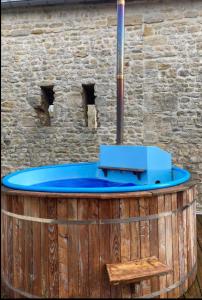 uma banheira azul sentada em cima de um barril de madeira em Le vieux moulin em Thaon