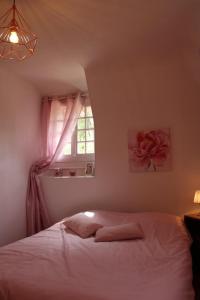 um quarto com uma cama branca e uma janela em Le vieux moulin em Thaon