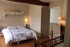 um quarto com uma cama e uma mesa com um candeeiro em Le vieux moulin em Thaon