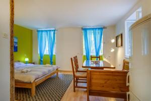 a bedroom with a bed and a desk and blue curtains at BigBlue house Apartman Amelie in Veli Lošinj
