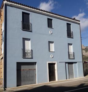 un edificio blanco con puertas y ventanas negras en CAL BAR, en Camarasa