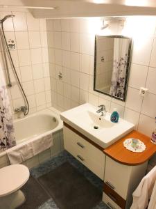 a bathroom with a sink and a tub and a toilet at RuheZeit - inclusive Pool & Sauna in Bad Harzburg