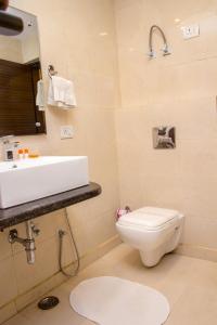 een badkamer met een witte wastafel en een toilet bij Hotel Pawan Plaza Near Sir Ganga Ram Hospital in New Delhi