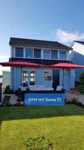 a blue house with a sign that reads better wait square at Wierhooft 21 in Den Oever