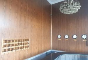 a room with clocks on the wall and a chandelier at Royal Crown Hotel عائلات فقط in Alexandria
