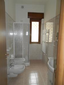 フィウミチーノにあるAppartamento Fiumicinoのバスルーム(トイレ2つ、シャワー、シンク付)