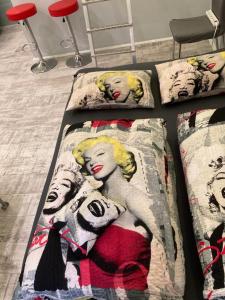 2 posti letto in una camera da letto con copriletto e una donna sopra di Marilyn City Center a Pécs