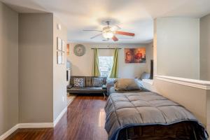 a bedroom with a couch and a ceiling fan at East Downtown Bungalow in Houston