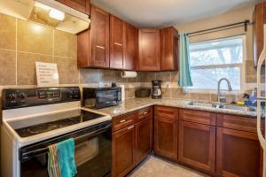 a kitchen with wooden cabinets and a stove top oven at East Downtown Bungalow in Houston