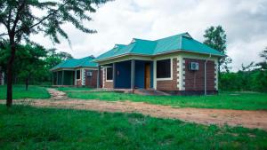 una pequeña casa con techo verde en MANTIS LODGE & CAMPING SITE, en Morogoro