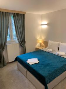 ein Schlafzimmer mit einem blauen Bett und einem Fenster in der Unterkunft Garni hotel Vir in Vrnjačka Banja