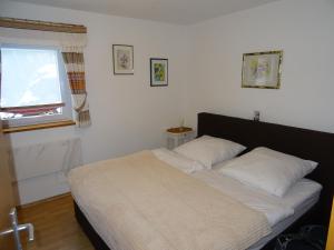 a bedroom with a bed with white sheets and a window at CU-Ferienwohnungen - nur für Urlaubsgäste in Grafenwiesen