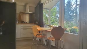 a kitchen with a table and chairs and a window at Vakantiebungalow De Schaapskooi in Epe