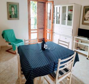 una sala da pranzo con tavolo e sedie blu di La casa del sole a Torre dell'Orso