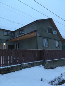 una casa con una valla en la nieve en Садиба у Надії, en Yasinya
