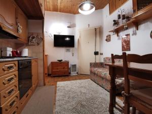 a kitchen and living room with a couch and a television at Roccaraso centro in Roccaraso